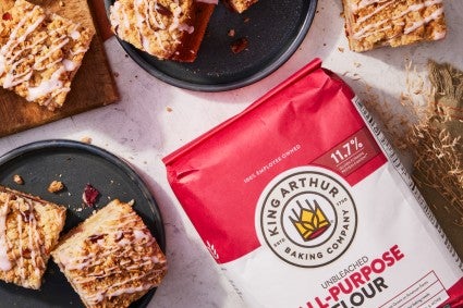 Bag of all-purpose flour next to slice of coffee cake