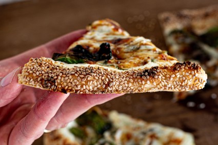 Close up of pizza crust with sesame seed exterior