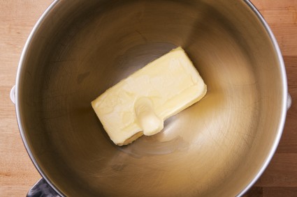 Softened butter with indent from a finger in a stand mixer bowl