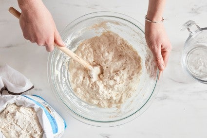 Baked stirring bowl of bread dough, which has formed a shaggy mass