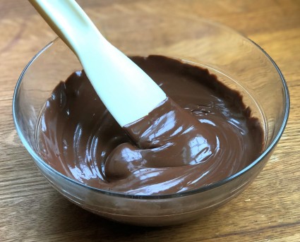 A bowl of thick, smooth chocolate ganache.