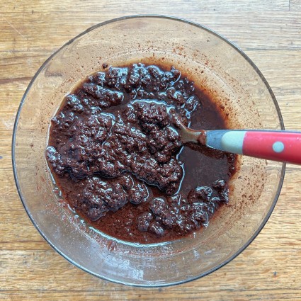 A bowl of ganache that's separated into granular chunks and oil.