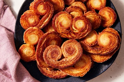 A plate of palmiers with a pink towel set to the side
