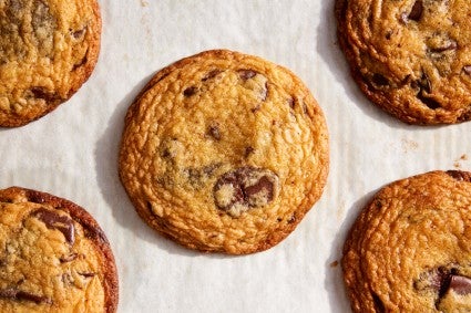 Several chocolate chip cookies on a parchment-lined baking sheet