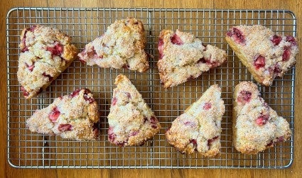 Fresh strawberry scones cooling on a metal cooling rack.