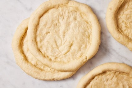 Parbaked rounds of pizza dough