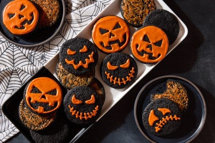 chocolate cookies decorated as jack o lanterns on a plate