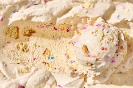 Birthday Cake Ice Cream in a container with a scoop