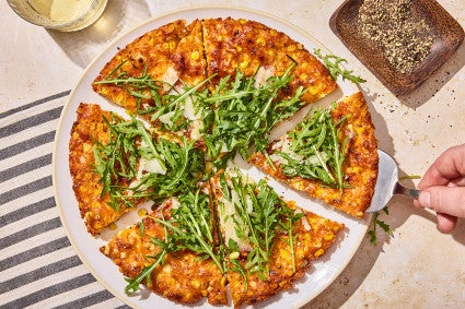 A Giant Cheesy Corn Fritter that has been sliced into pieces