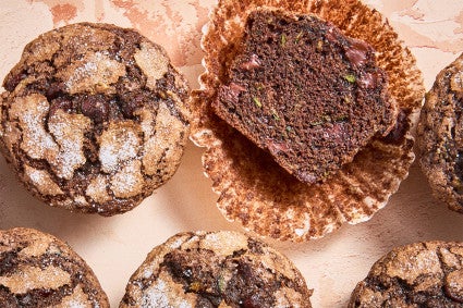 Several Chocolate Zucchini Muffins with one halved