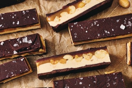 A closeup shot of Chocolate Peanut Nougat Bars showing layers of nougat, peanuts, and chocolate.