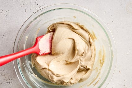 Cookie Butter Whipped Ganache being made in a clear class bowl.
