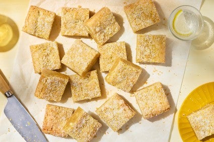 Alex Roberts Lemon Citrus Blondies on parchment paper atop a counter.