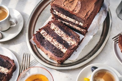 Chocolate Cassata Cake on a plate with a slice laying down showing layers of chocolate and creamy filling.