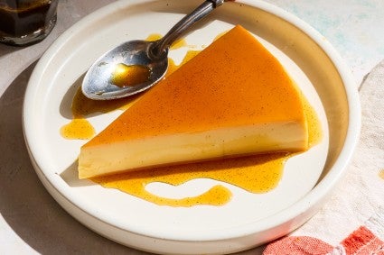A slice of flan on a white plate.