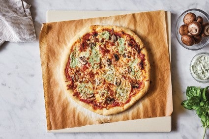 Pizza baked on a parchment paper lined baking stone