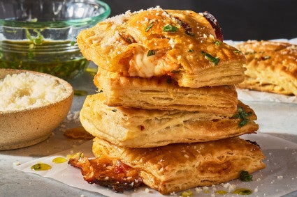 A stack of Flaky Puff Crust Pizza Turnovers seen from the side.