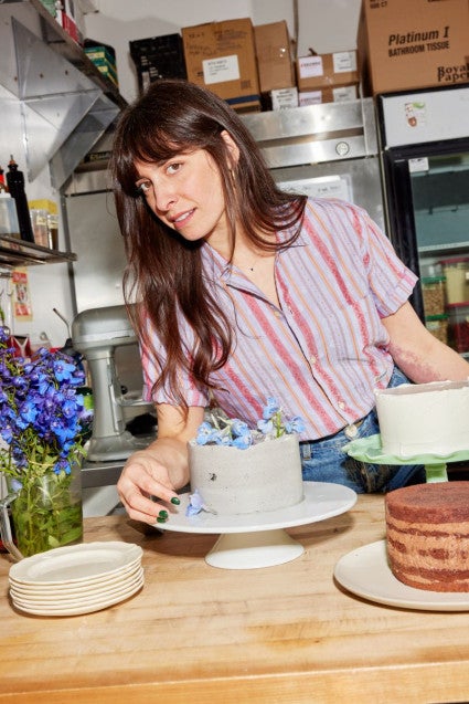 Hannah Ziskin in a kitchen surrounded by layer cakes