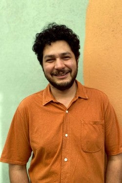 Arturo standing in front of a colorful wall