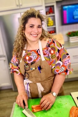 Milena slicing at a cutting board in the kitchen