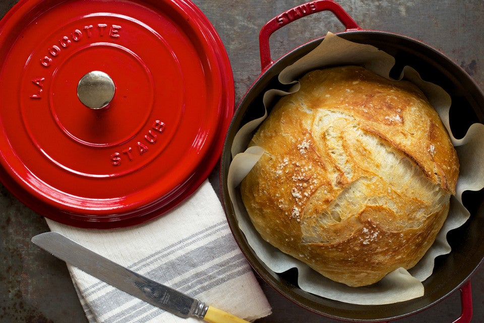 An overhead photo of a loaf of crusty bread that was baked in a round Dutch oven. 