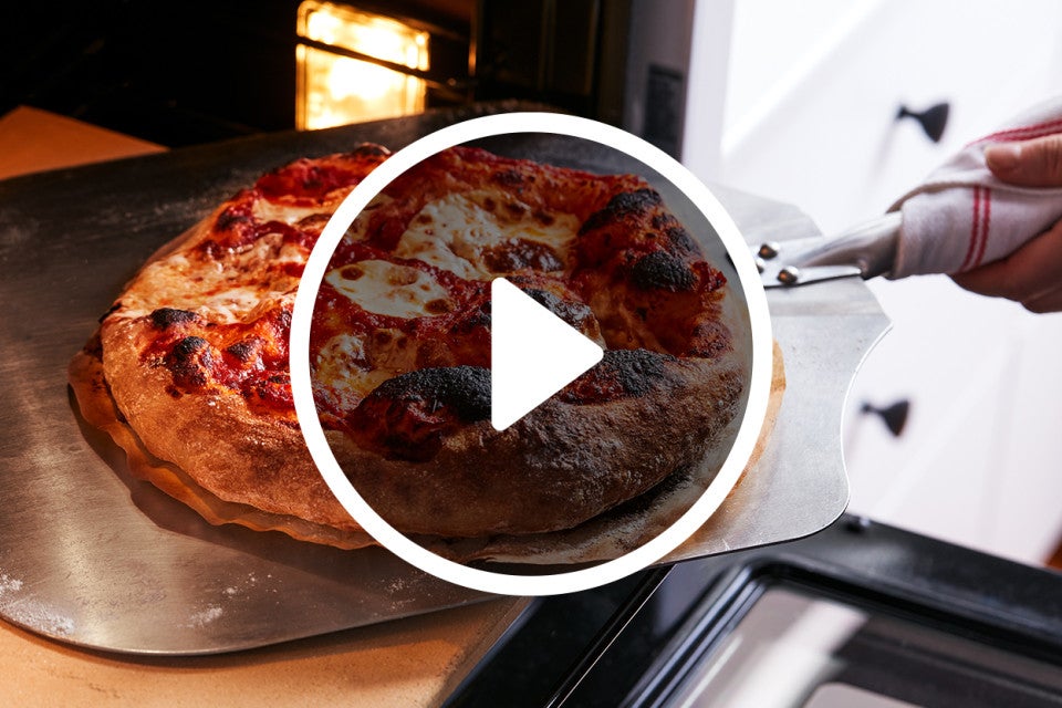 Pizza coming out of an oven