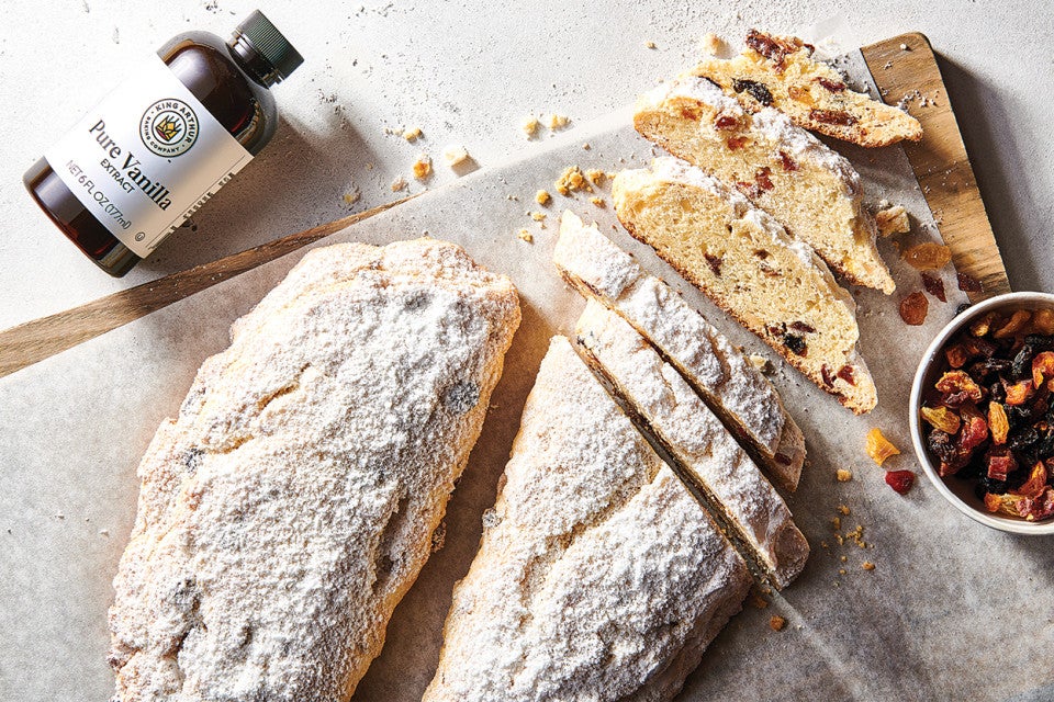 Our Easiest Stollen on a cutting board with dried fruit mix and vanilla extract