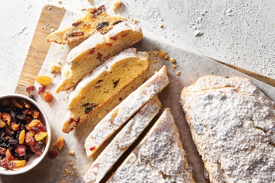 Our Easiest Stollen on a cutting board with dried fruit mix and sliced into pieces