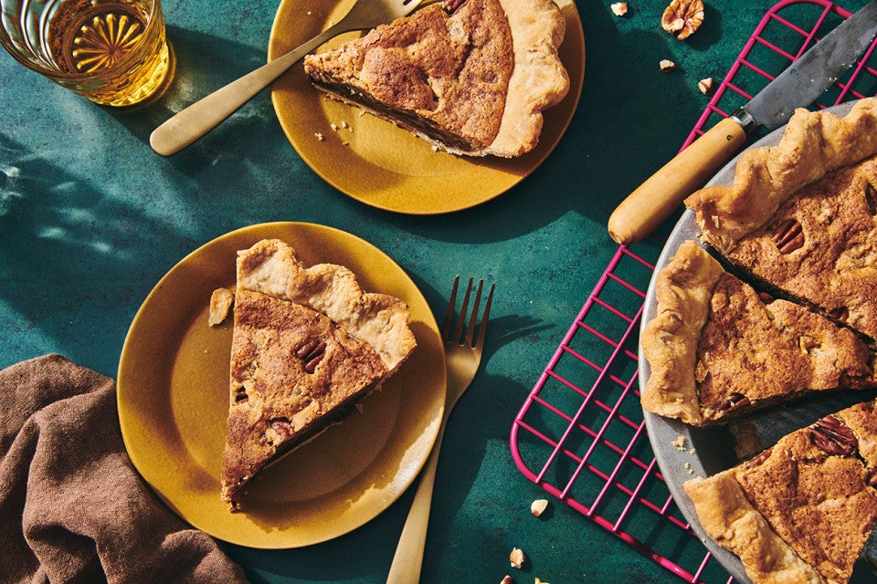 Slices of Chocolate Chip Pecan Pie on plates next to the full pie