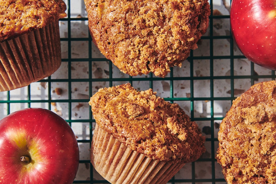 A close-up shot of freshly baked apple muffins on a cooling rack.
