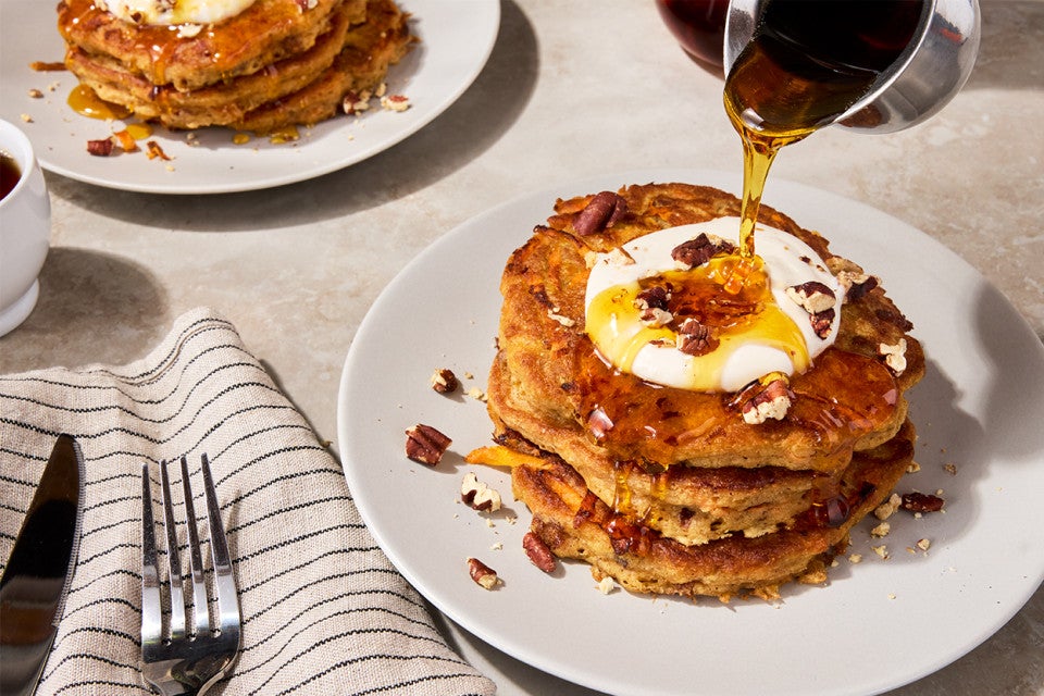 Carrot Cake Pancakes on a plate with syrup pouring over them