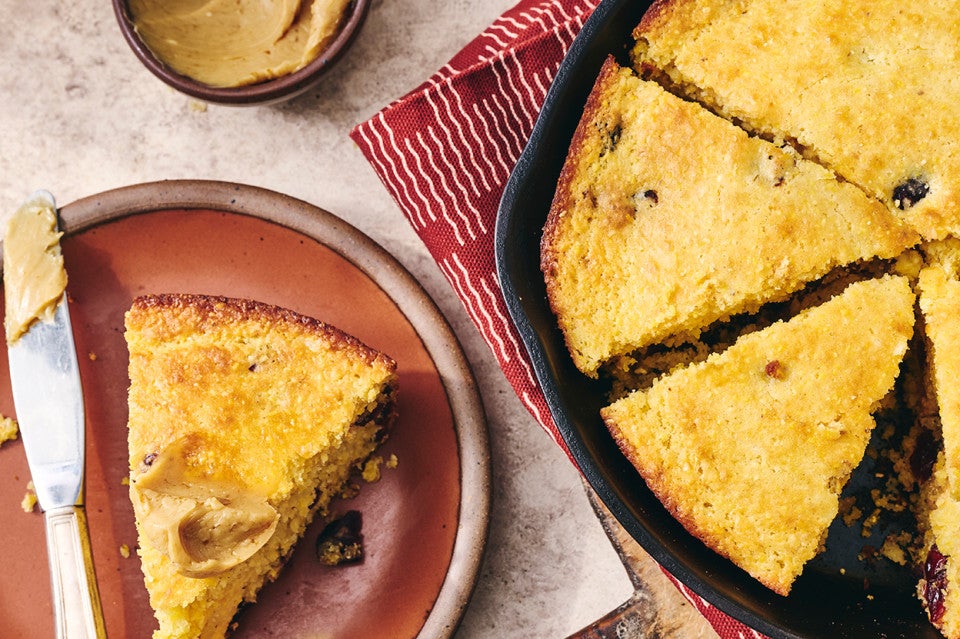 Cranberry Cornbread sliced and in a cast iron pan