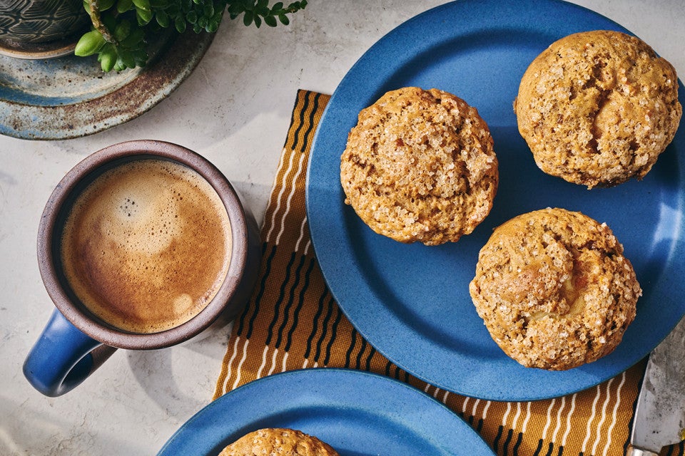 Cream Cheese Carrot Cake Muffins on a plate with a cup of coffee