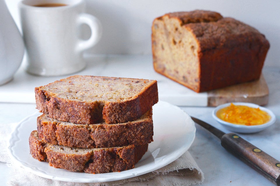 Banana bread stacked on a plate with the rest in the background