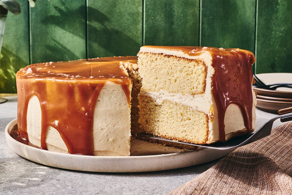 Caramel Layer Cake with Brown Butter Frosting with a slice being taken out