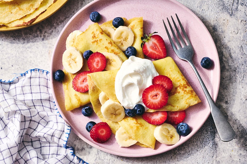 Gluten-Free Crêpes on a plate with berries and cream