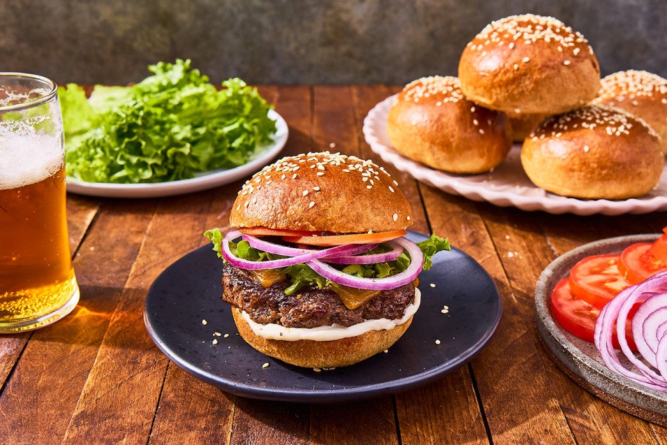 A hamburger on a plate made on a 100% Whole Wheat Hamburger Bun