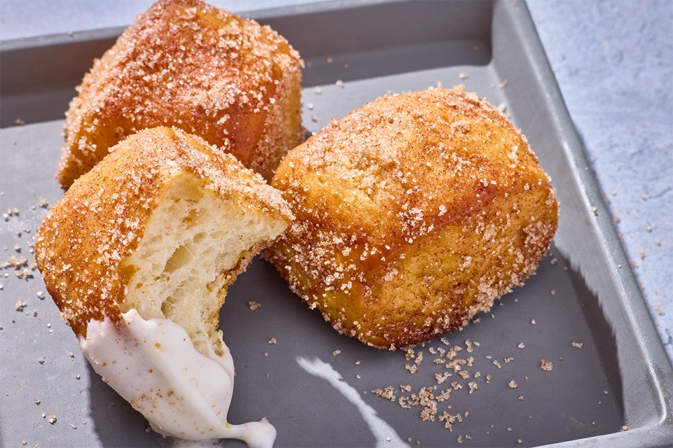 Cinnamon-Sugar Pretzel Bites on a plate, one with a bite out of it