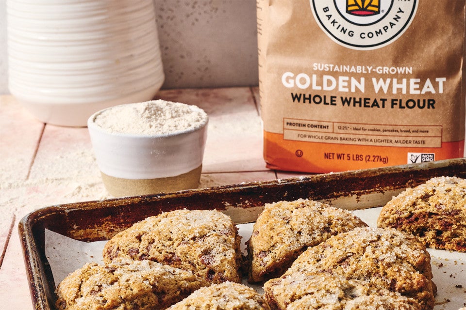 Cinnamon Whole Wheat Scones on a baking sheet with a cup of coffee
