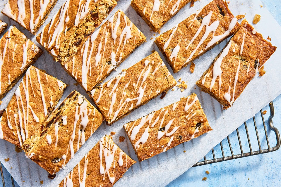 Oatmeal Raisin Cookie Bars sliced up on parchment on a cooling rack
