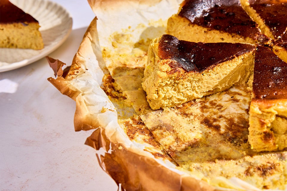 Pumpkin Basque Cheesecake sliced into pieces on a sheet of parchment