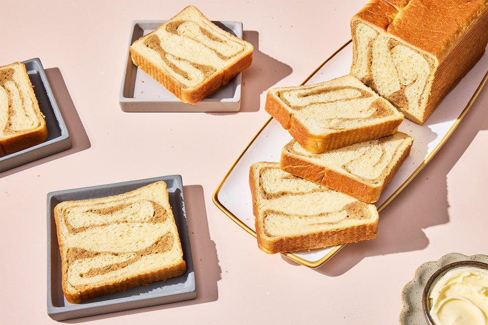 Swirled Maple Milk Bread on a cutting board and slices served on plates