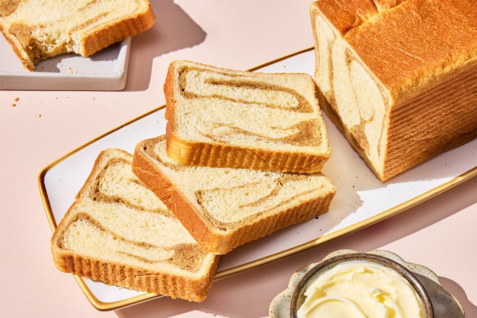 A sliced loaf of Swirled Maple Milk Bread on a serving tray