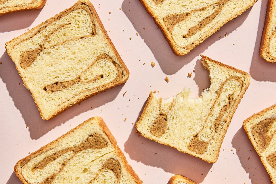 Slices of Swirled Maple Milk Bread; one with a bite taken out of it