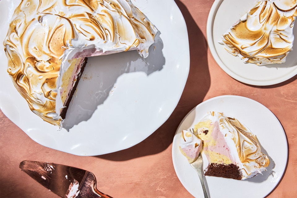 Baked Alaska served on a plate with the full cake on a platter
