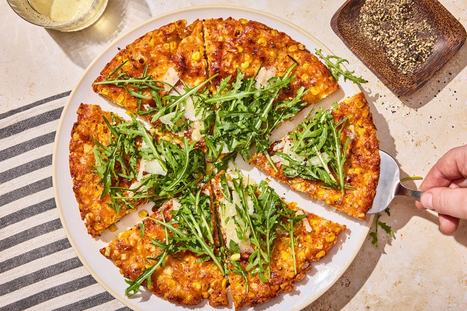 A Giant Cheesy Corn Fritter that has been sliced into pieces