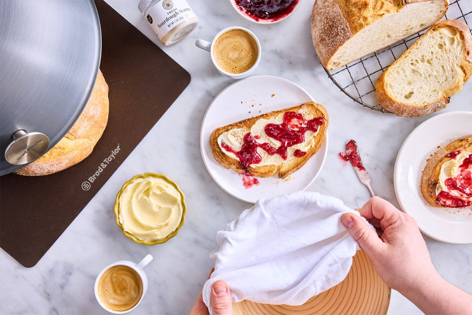 Extra-Tangy Sourdough Bread sliced on a plate with butter and jam