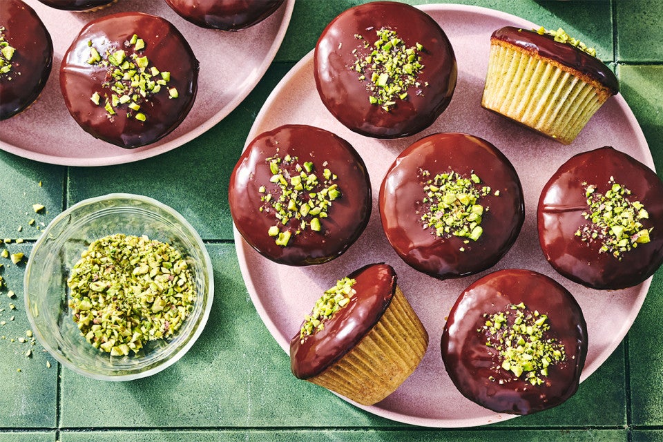 Pistachio-Cardamom Cupcakes with Dark Chocolate Ganache on a plate