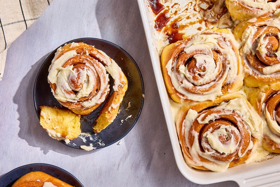 A Sweet Potato Cinnamon Roll on a plate; a bunch in a casserole dish