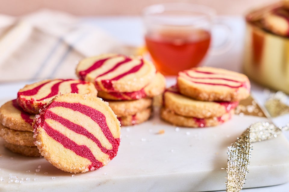 A counter-level view of striped peppermint shortbread cookies showing the scale and shape of the cookie.